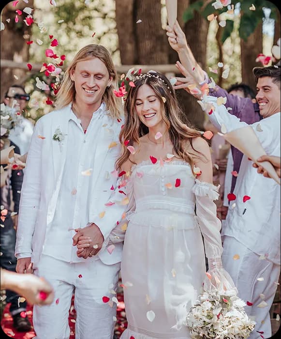 Newly married couple walks down the aisle covered in confetti