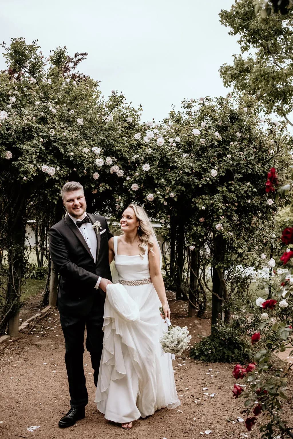 alison_and_brock_walking_through_rose_garden_archway_a84c2fcfd0