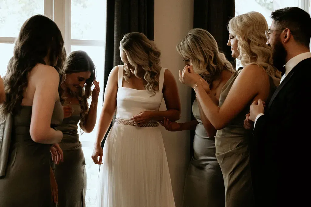 bride_getting_ready_with_bridesmaids_candid_moment_369976cadf